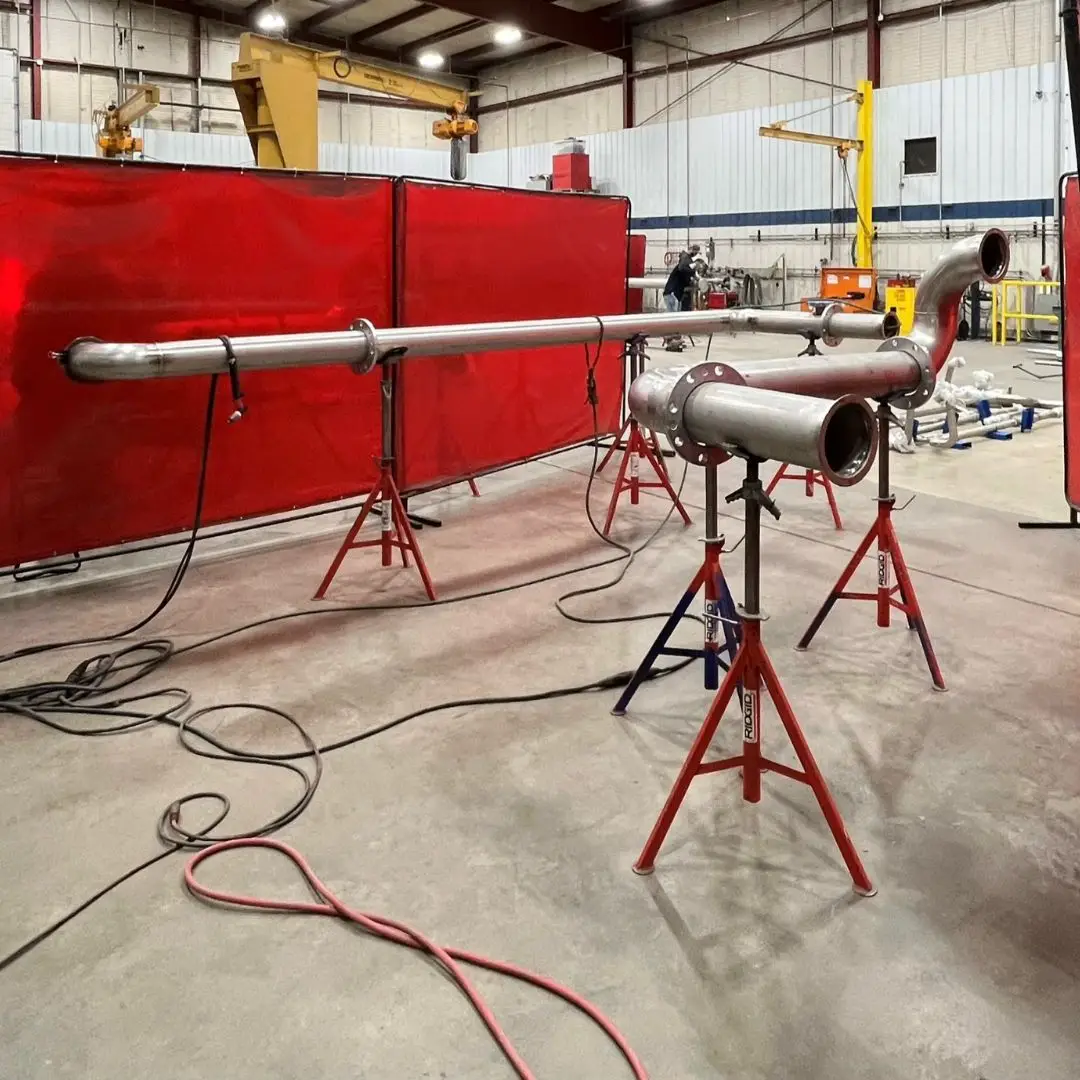 Pipe spools on pipe stands in a fabrication workshop