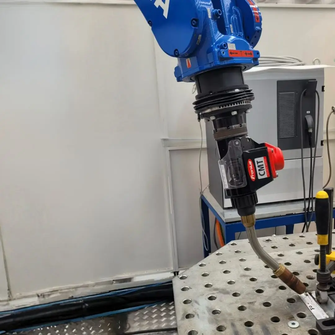 Robotic welding torch above a fixture table