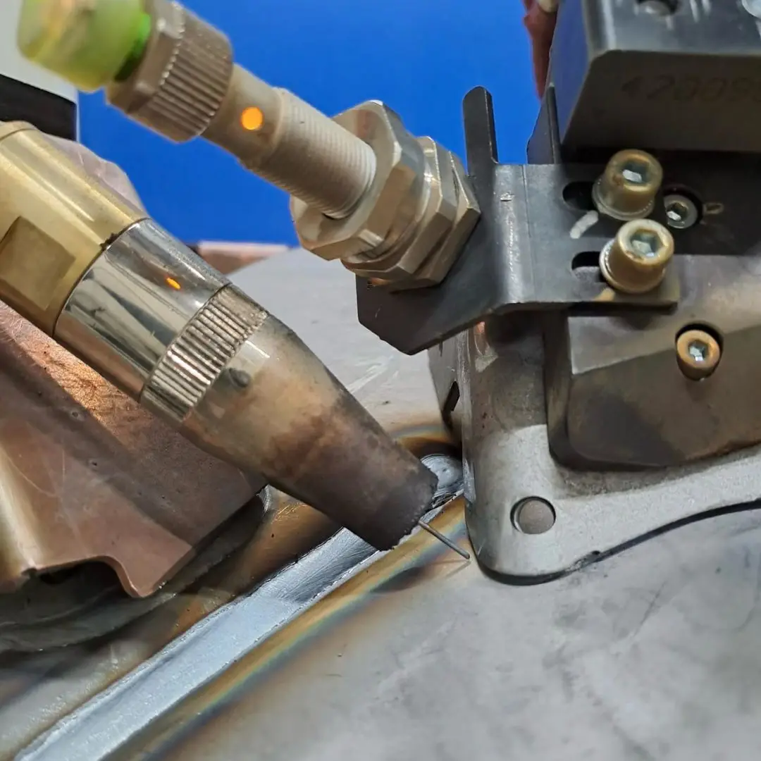 Robotic torch welding a sheet-metal joint with a seam-tracking sensor