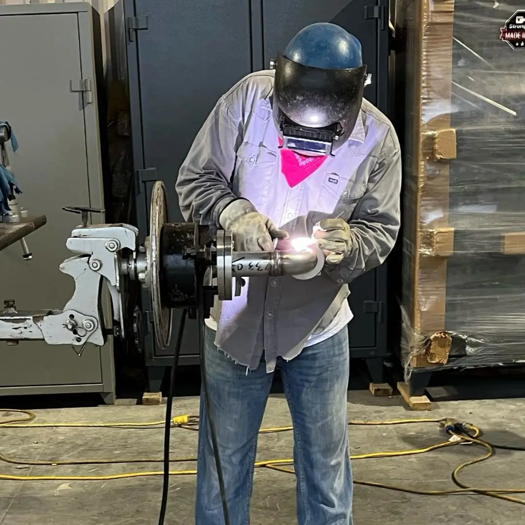 Welder welding a component on a rotating positioner
