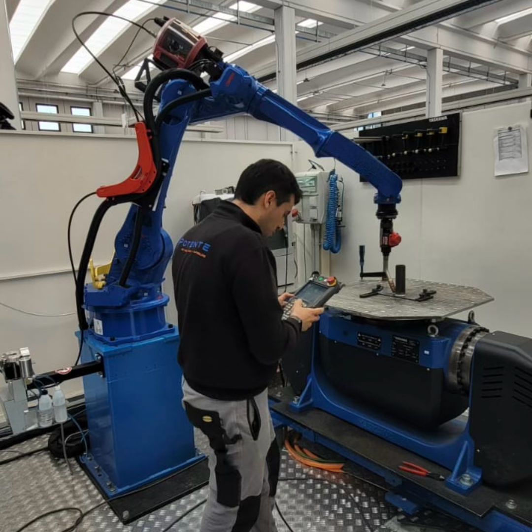 Operator programming a welding robot with the teach pendant